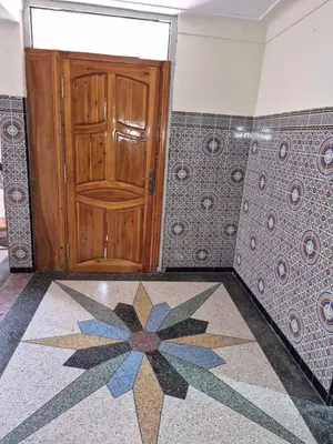 a wooden door in a room with a tile floor at Villa appartement jardin et piscine in Meknès