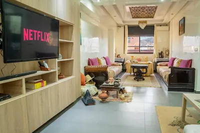 a living room with a television on a wall at VIP Luxury Stay Béni Mellal in Beni Mellal