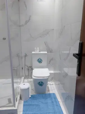 a bathroom with a toilet and a glass shower at Beautiful Apartment for Rent in Corniche de Rabat in Oulad Akkou
