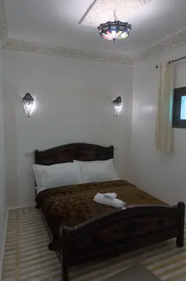 a bedroom with a bed with a robe on it at Riad Dalal in Fès