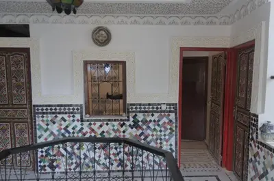 a room with a staircase and a door with a tile wall at Riad Dalal in Fès