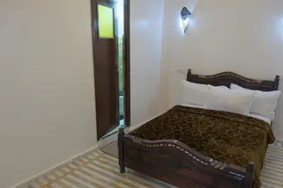 a bedroom with a bed and a mirror at Riad Dalal in Fès