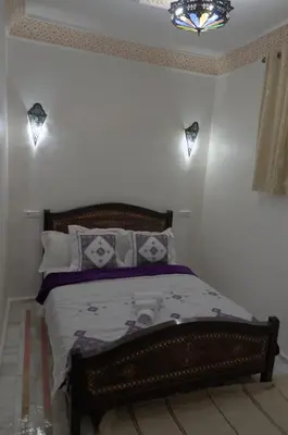 a bedroom with a wooden bed with pillows at Riad Dalal in Fès