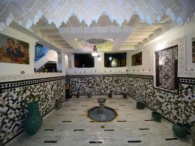 a room with a tile floor with a table in it at Riad Dalal in Fès