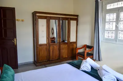a bedroom with a bed and a wooden cabinet at Dar sarah médina Fés in Fès