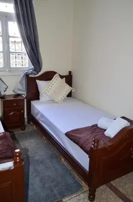 a bedroom with a wooden bed and a window at Dar sarah médina Fés in Fès