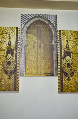 a gold door with two handles on a wall at Dar sarah médina Fés in Fès