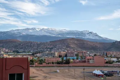 a city with snow capped mountains in the background at app luxe in Beni Mellal
