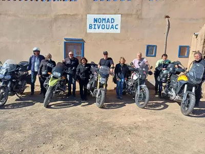 a group of people posing for a picture with their motorcycles at Isolé Bivouac Merzouga in Merzouga