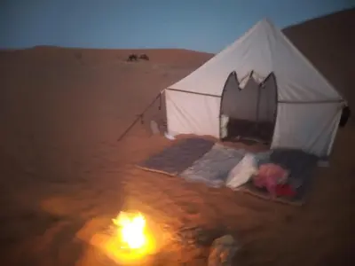 a tent in the desert with a fire in it at Isolé Bivouac Merzouga in Merzouga