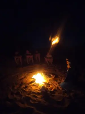 a fire burns in the sand at night at Isolé Bivouac Merzouga in Merzouga