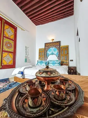 a room with a table with cups and a bed at Riad Slima Fes in Fès