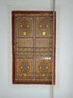 a wooden window on a wall with a chain at Riad Slima Fes in Fès