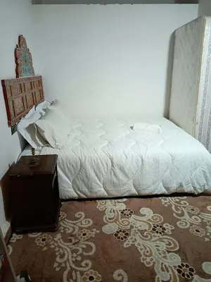 a bedroom with a white bed and a table at Riad Slima Fes in Fès