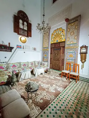 a living room with a couch and a wooden door at Riad Slima Fes in Fès