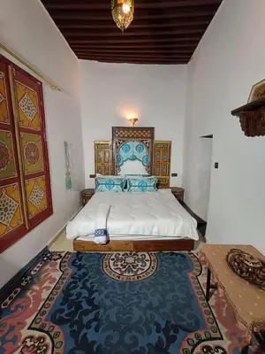 a bedroom with a king sized bed with a rug at Riad Slima Fes in Fès