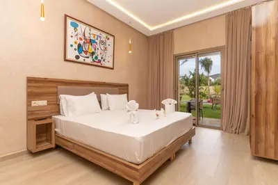 a bedroom with a large bed and a large window at Villa Hasard Marrakech in Had Abdallah Rhiat