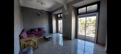 a living room with a purple couch and windows at Bright apartment with balcony in the center of FES in Fès