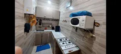 a small kitchen with a stove and a microwave at Bright apartment with balcony in the center of FES in Fès