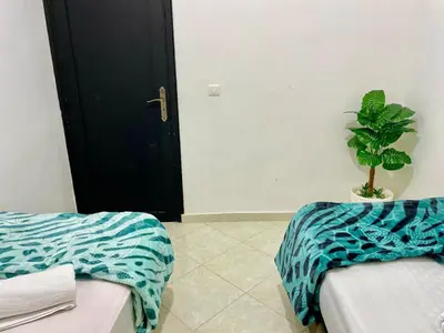a room with two beds and a potted plant at Chic apartment in Fes luxurious and family friendly in Oulad Akkou