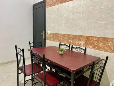 a dining room table with chairs and a plant on it at Chic apartment in Fes luxurious and family friendly in Oulad Akkou