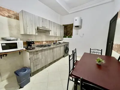a kitchen with a table and a stove and a microwave at Chic apartment in Fes luxurious and family friendly in Oulad Akkou