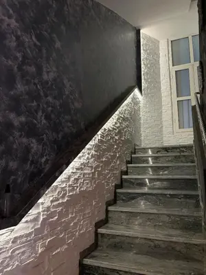 a staircase with a brick wall and a window at Welcome to your Stylish apartment in Oulad Akkou