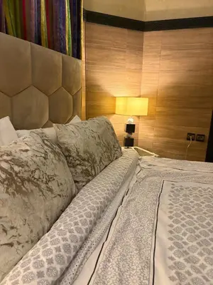 a bedroom with a large bed with a wooden wall at Welcome to your Stylish apartment in Oulad Akkou