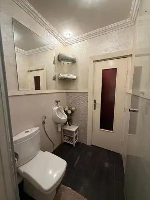 a bathroom with a toilet and a mirror and a door at Welcome to your Stylish apartment in Oulad Akkou