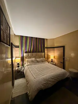 a bedroom with a large bed and two lamps at Welcome to your Stylish apartment in Oulad Akkou