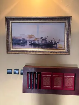 a picture of a boat on a shelf with books at Welcome to your Stylish apartment in Oulad Akkou