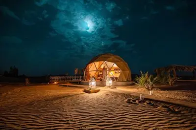a domed building in the middle of a desert at night at Erg Chebbi Luxury Geodesic Camp in Merzouga