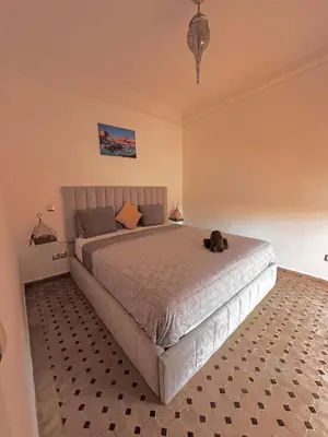 a bedroom with a bed with a dog sitting on it at Nid avec jacuzzi en centre ville in Oulad Akkou
