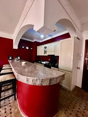 a kitchen with a red and white island in a room at Nid avec jacuzzi en centre ville in Oulad Akkou