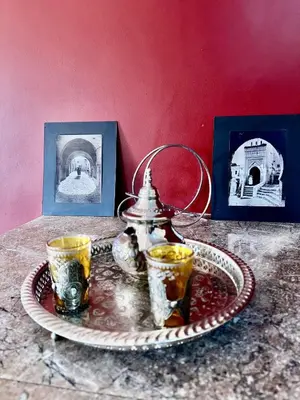 a plate with a tea pot and two cups on a table at Nid avec jacuzzi en centre ville in Oulad Akkou