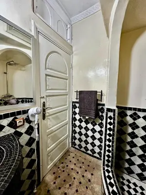 a bathroom with a black and white checkered floor at Nid avec jacuzzi en centre ville in Oulad Akkou