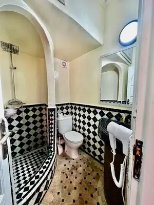 a bathroom with a shower and a toilet and a sink at Nid avec jacuzzi en centre ville in Oulad Akkou