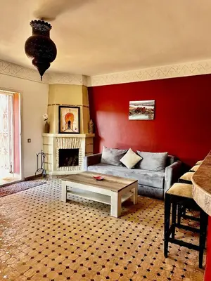 a living room with a couch and a fireplace at Nid avec jacuzzi en centre ville in Oulad Akkou