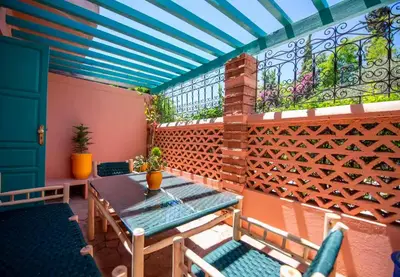 a patio with a table and chairs and a window at Modern Elegance & Moroccan Charm 5 min Hivernage in Oulad Akkou