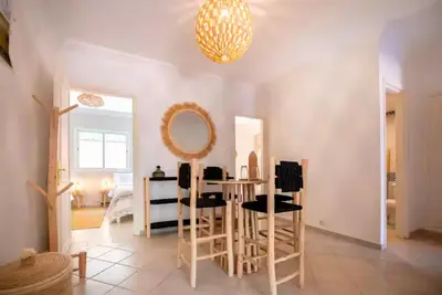 a room with a table and chairs and a mirror at Modern Elegance & Moroccan Charm 5 min Hivernage in Oulad Akkou