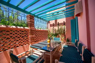 a patio with a table and chairs and a fence at Modern Elegance & Moroccan Charm 5 min Hivernage in Oulad Akkou