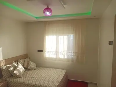a bedroom with a bed and a window with a light at مفتاح الساحل in Oulad Akkou