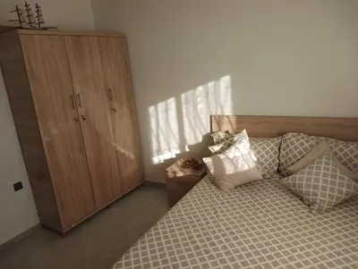a bedroom with a bed and a wooden cabinet at مفتاح الساحل in Oulad Akkou