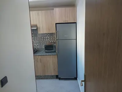 a kitchen with a stainless steel refrigerator and wooden cabinets at مفتاح الساحل in Oulad Akkou