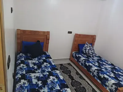 two beds sitting next to each other in a bedroom at مفتاح الساحل in Oulad Akkou