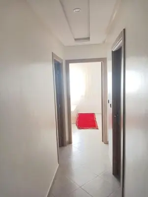 a hallway with a door and a red rug at مفتاح الساحل in Oulad Akkou