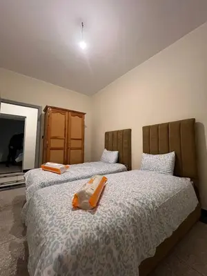 two beds sitting next to each other in a bedroom at Desert Getaway Apartment In Ouarzazate in Ouarzazate