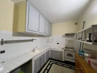 a kitchen with white cabinets and a sink and a stove at Desert Getaway Apartment In Ouarzazate in Ouarzazate