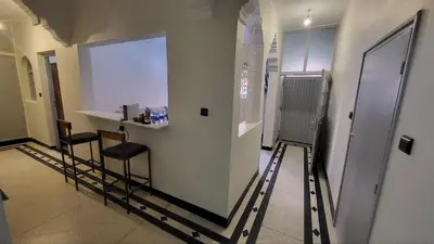a hallway with two chairs and a white wall at Desert Getaway Apartment In Ouarzazate in Ouarzazate