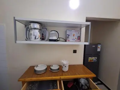 a small kitchen with a table and a refrigerator at Desert Getaway Apartment In Ouarzazate in Ouarzazate